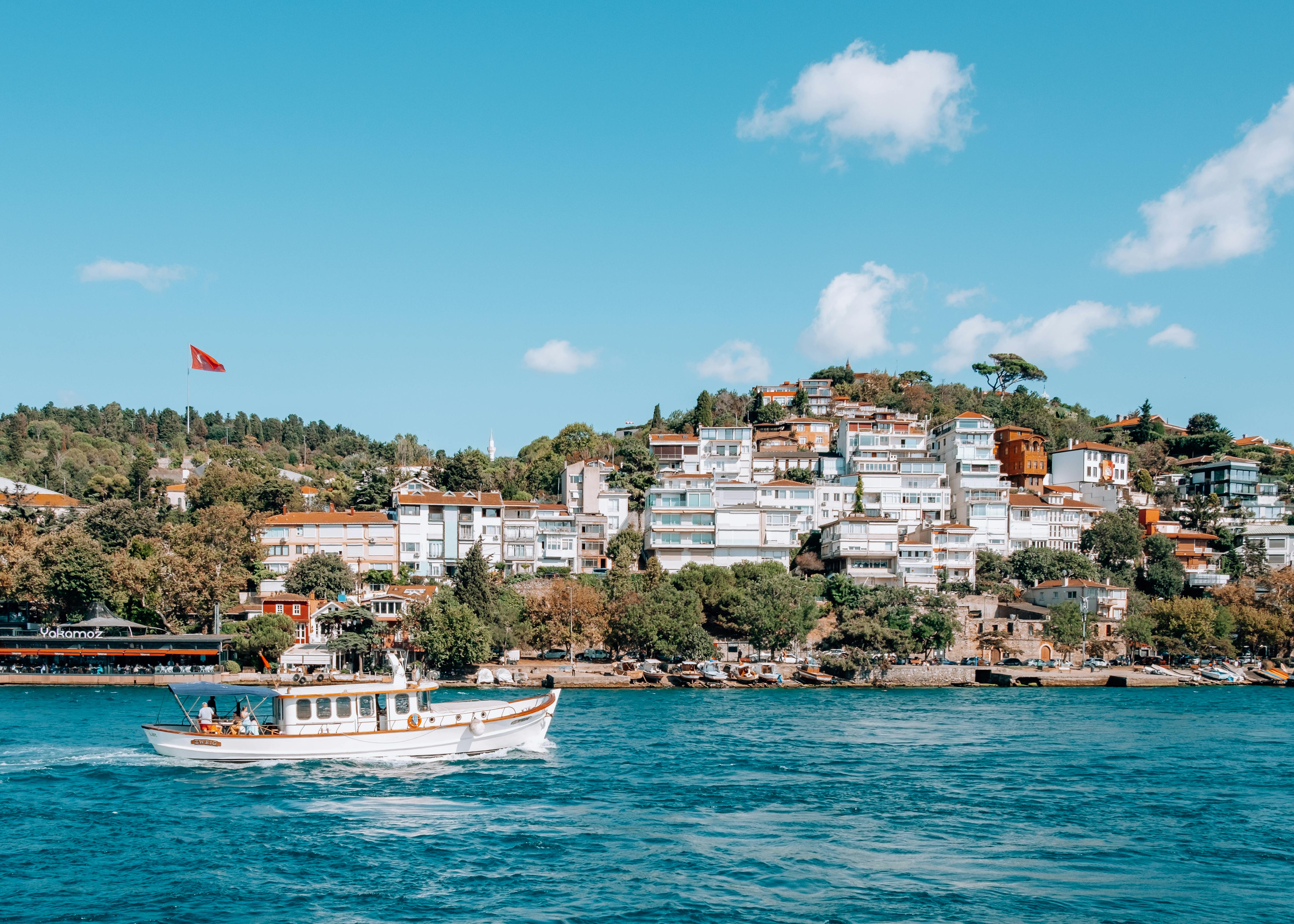 Wooden boat sails on the Bosphorus, with Istanbul's European side in the background.